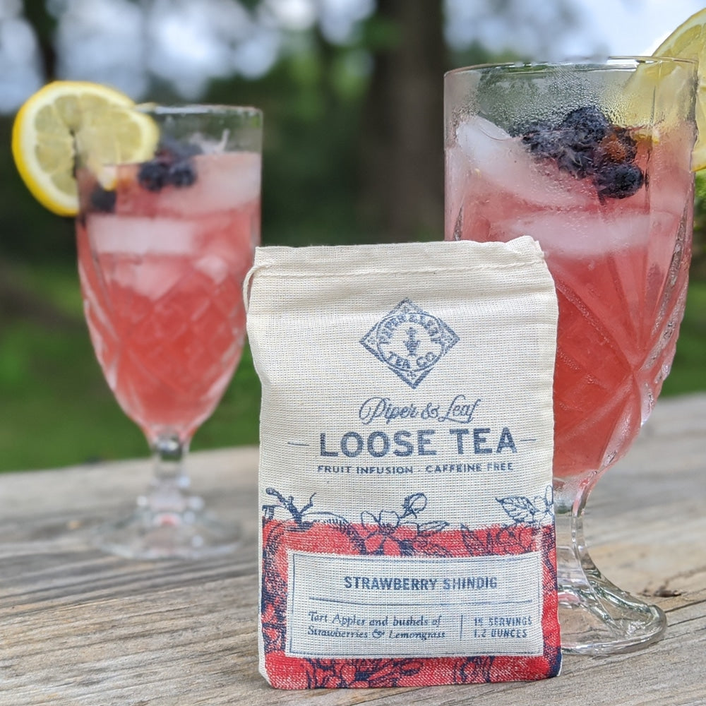 A bag of strawberry shindig sitting beside two glasses of delicious strawberry lemonade